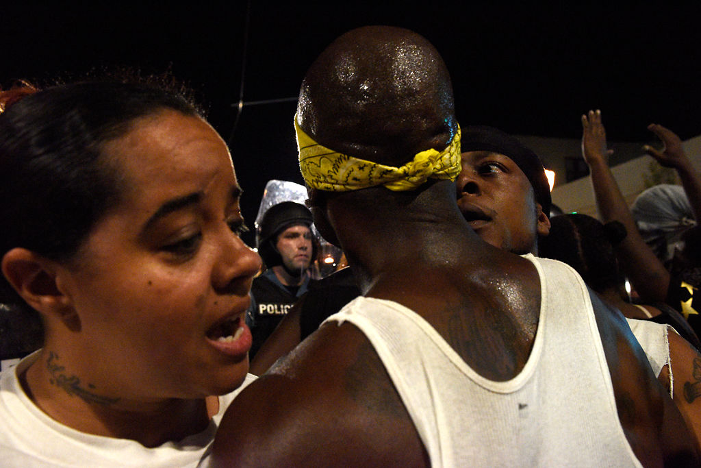 Fellow protestors talk to Mell Moffitt